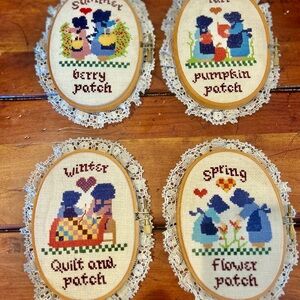 Vintage Paragon wood-framed cross-stitch pieces representing the four seasons.